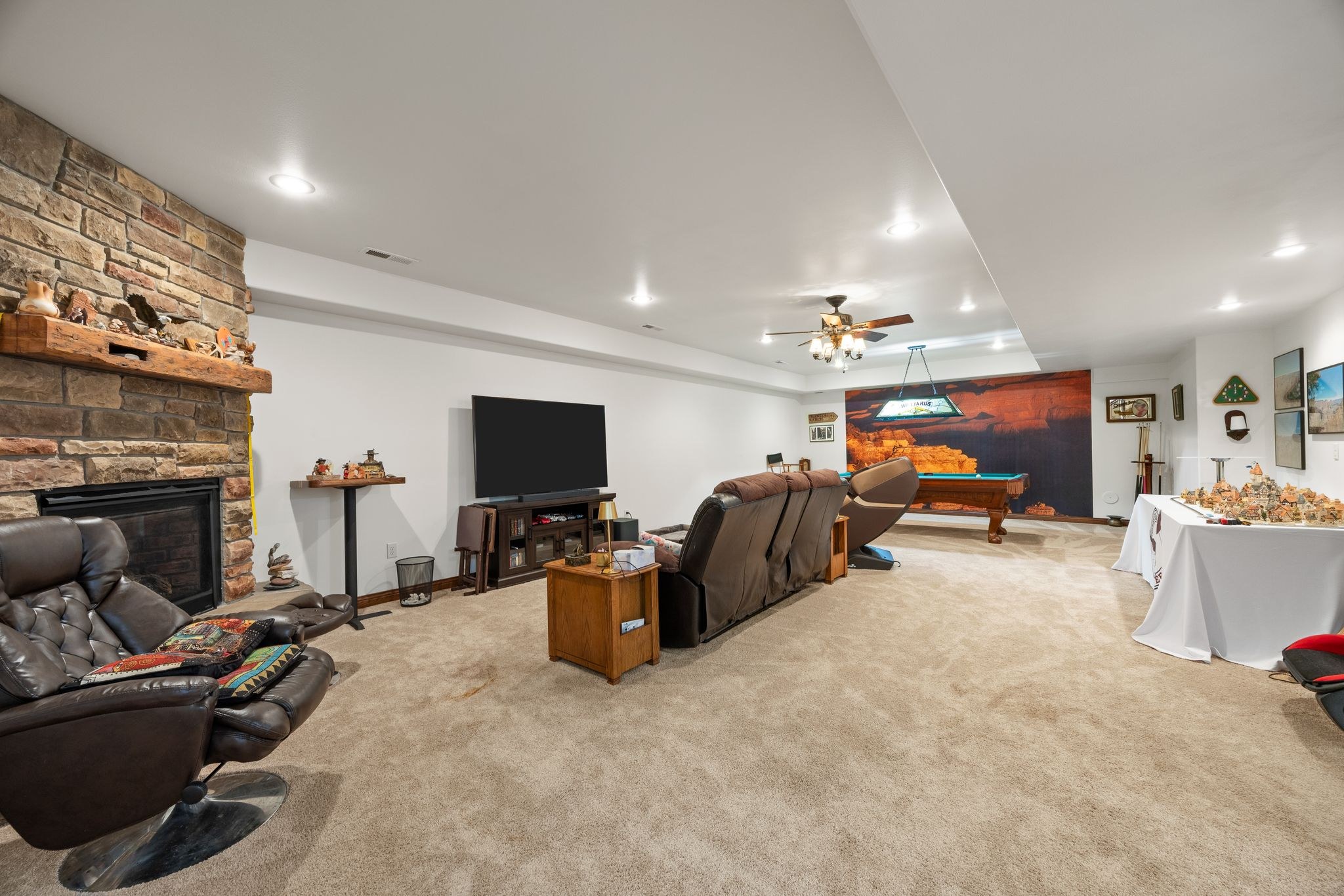 Basement recreation room with seating, fireplace, and pool table