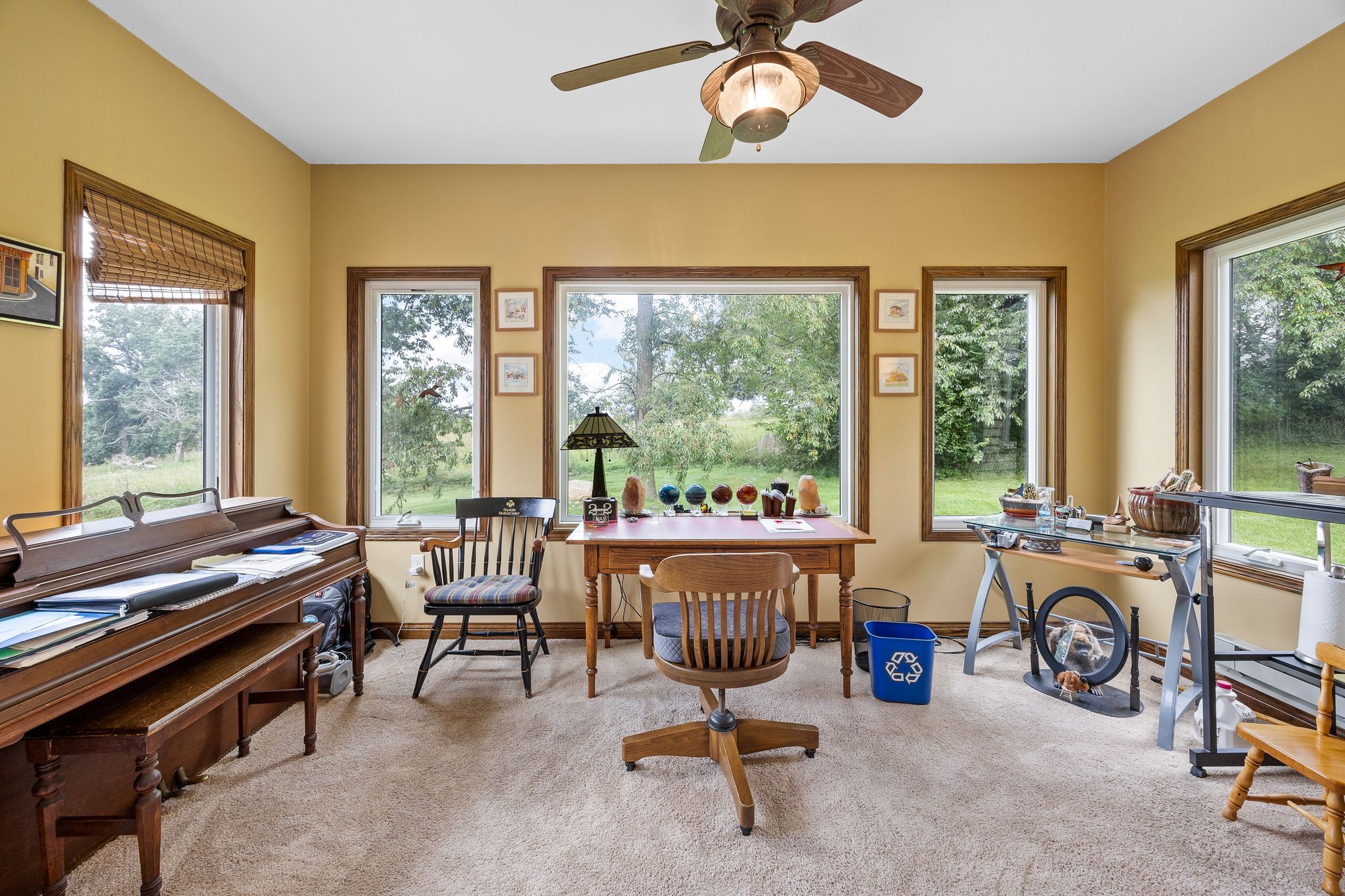 Sunroom office with a desk and windows on three sides